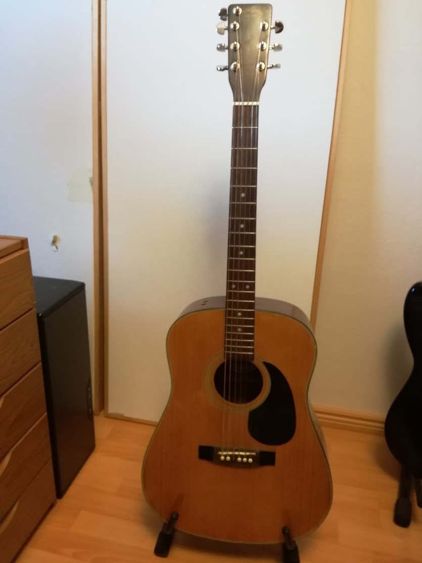 Akustinen kitara jalustalla.