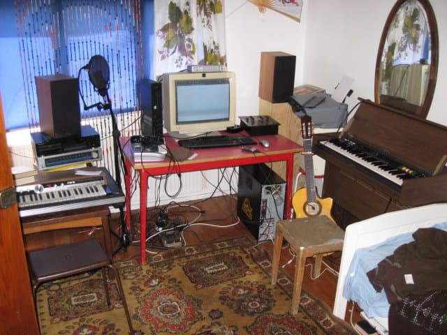 Vanhempi kuva kotistudiosta. Tietokone, kitara, kaksi urkua, ym.